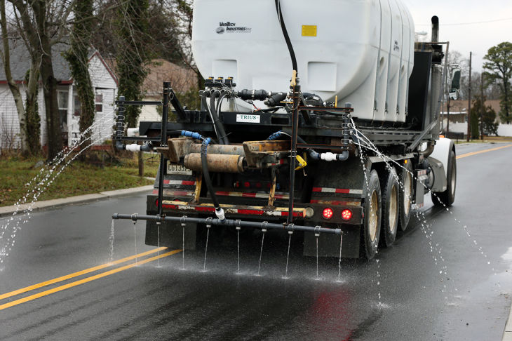 Truck with brine released from the back on a road.